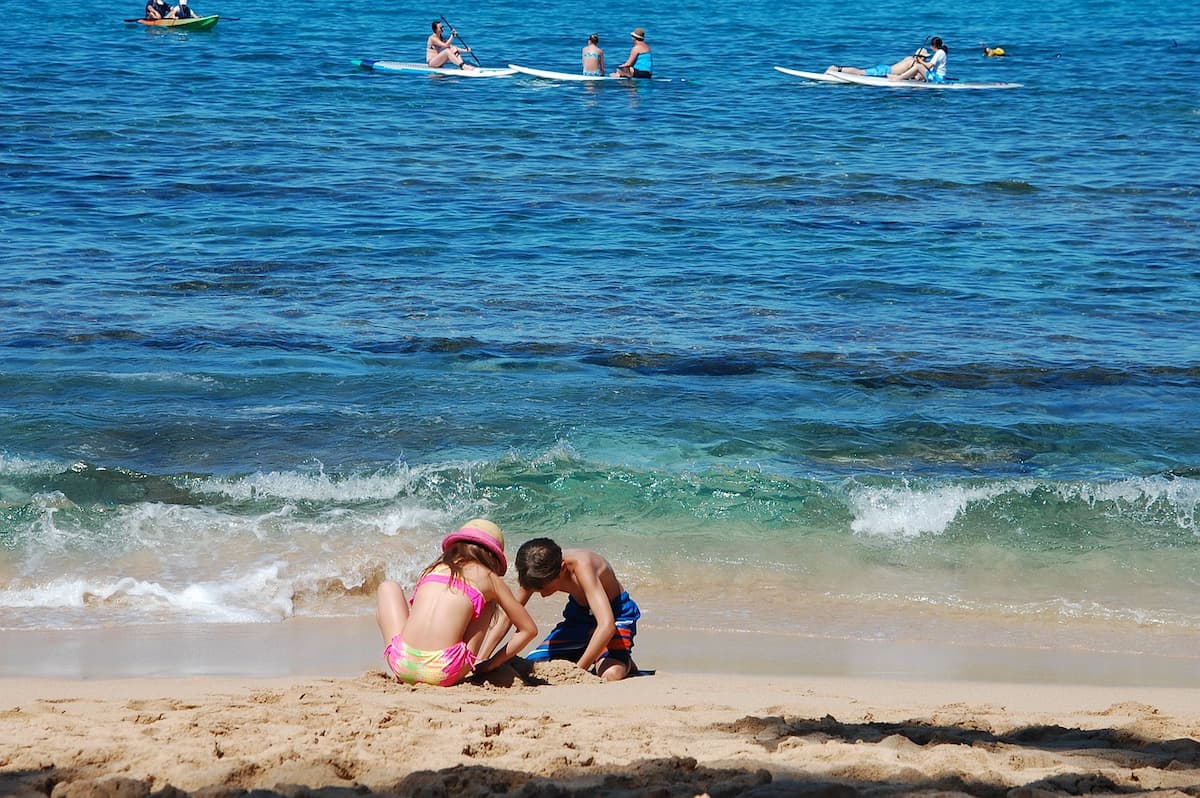 Kinder spielen am Strand